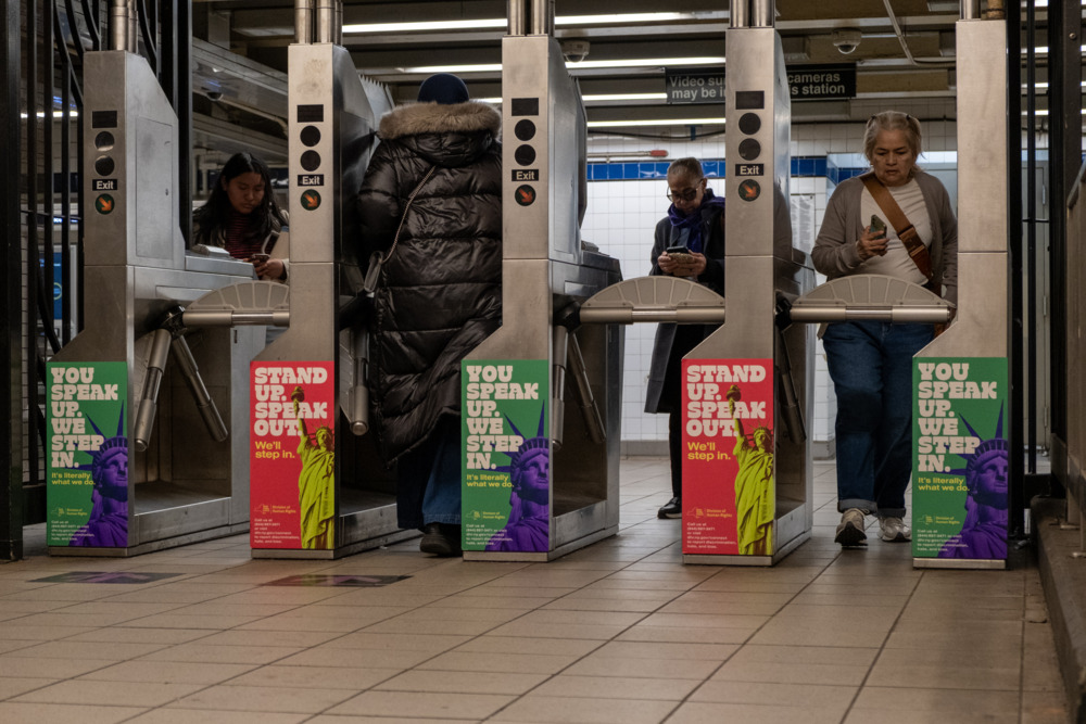OpAD Media New York State Division of Human Rights out-of-home OOH transit advertising placement at New York City subway turnstile — You Speak Up We Step In multicultural outdoor media buying